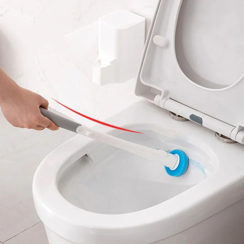 Hand using toilet cleaning brush with blue scrubber to clean toilet bowl