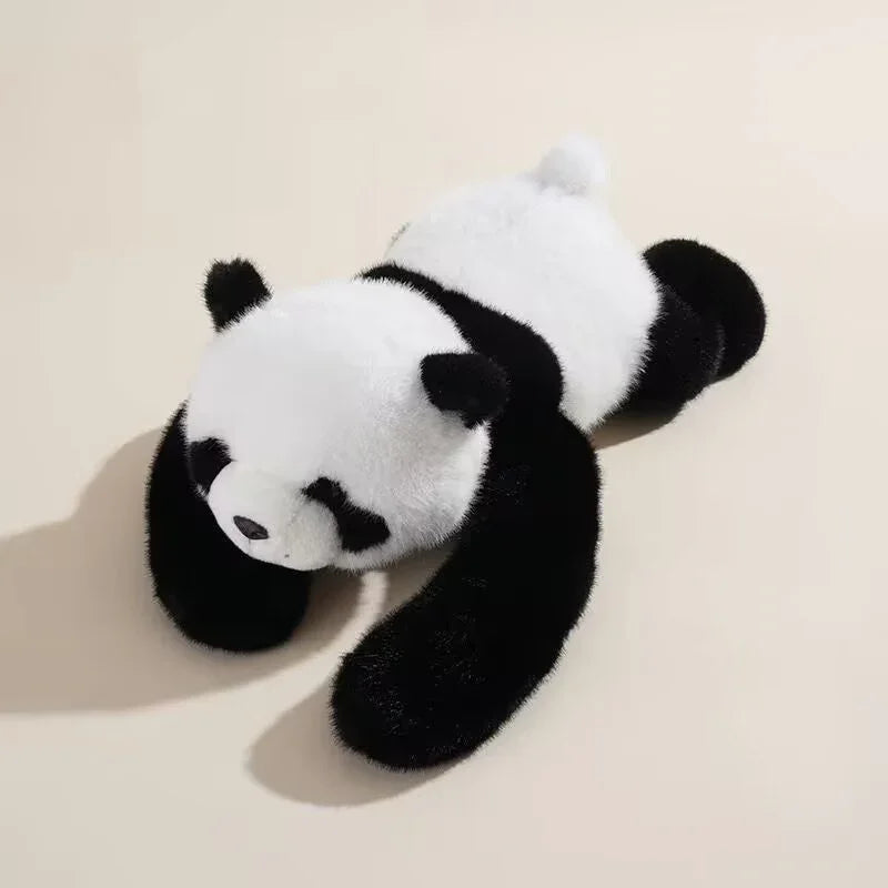 Plush panda stuffed animal toy lying on a light background