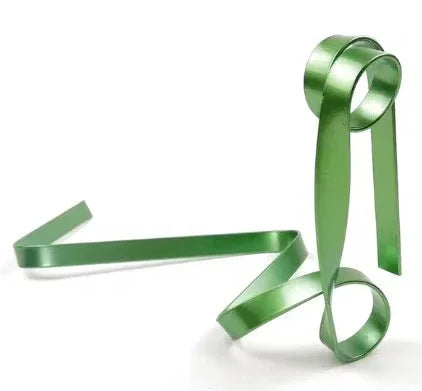 Shiny green metal ribbon sculpture in abstract loop design on white background