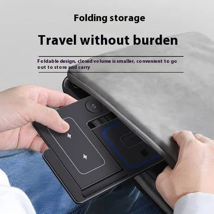 Person putting a foldable portable wireless charging pad into a laptop bag for easy travel.