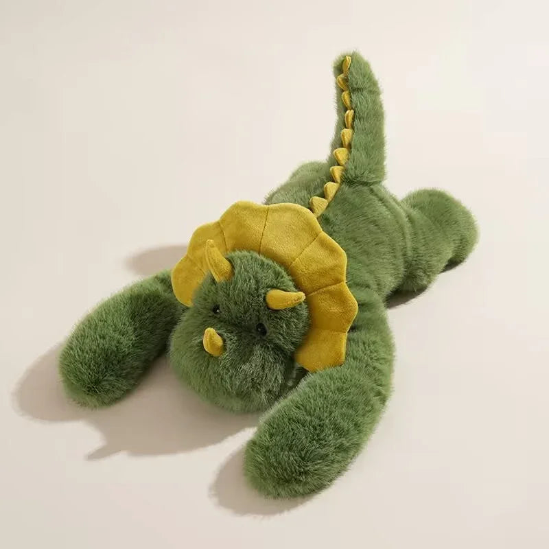 Green plush dinosaur stuffed toy with yellow horns and frill on a light background