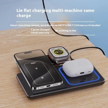 Wireless charging pad charging smartphone, smartwatch, and earbuds on wooden surface